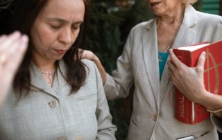 two women hand on shoulder